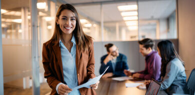 product manager smiles as her team meets behind her