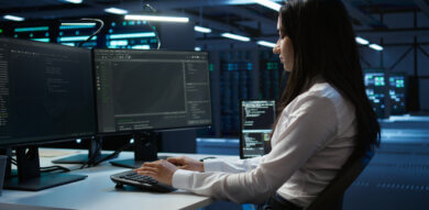 government UX designer works on efficiency in front of two screens